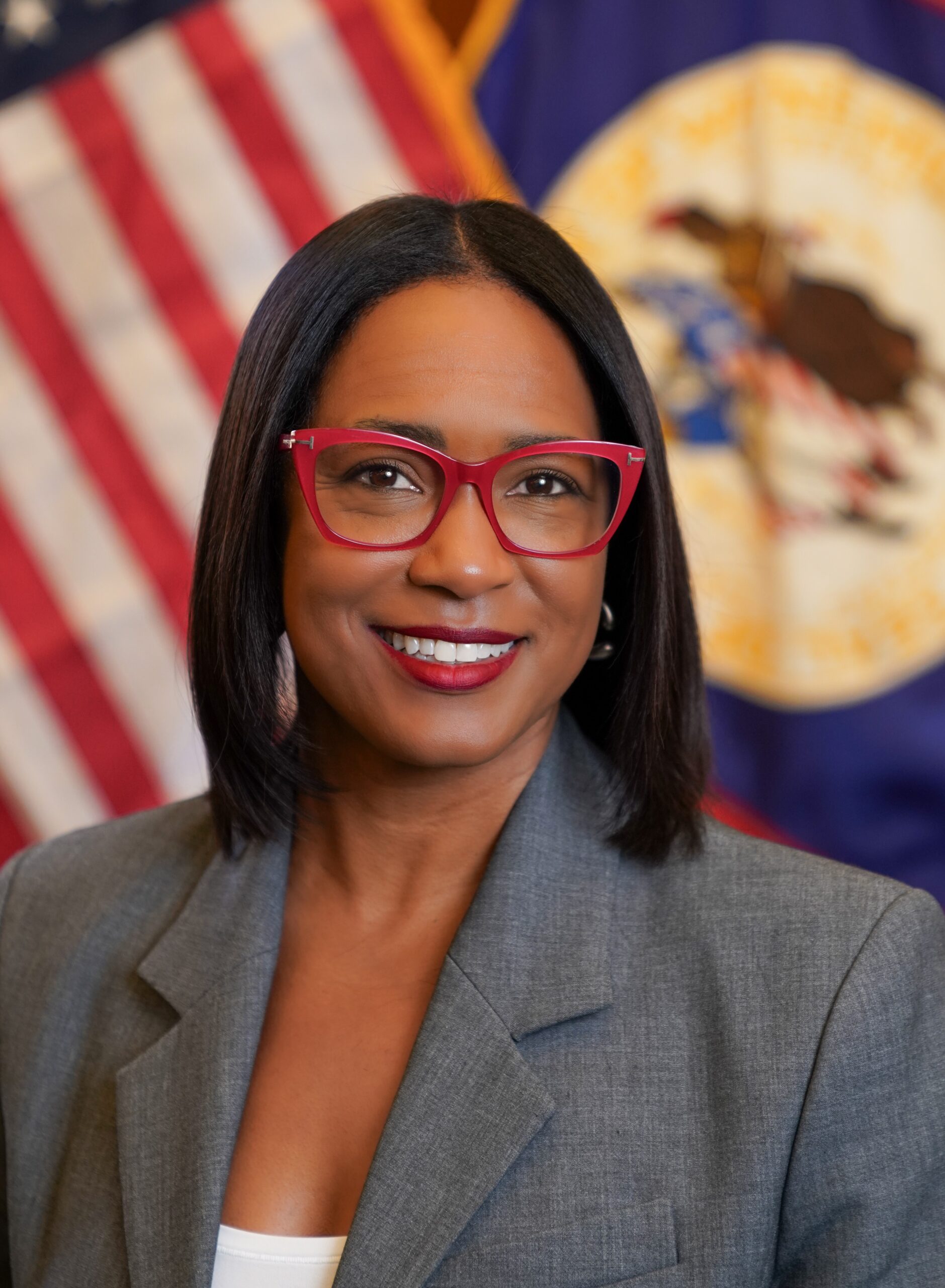 A woman in red glasses with a USA flag in the background
