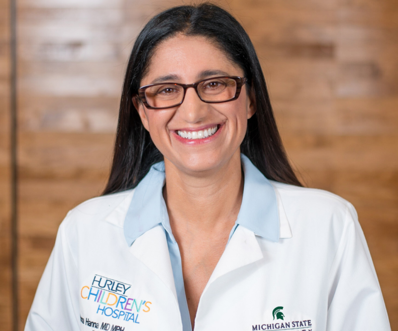 A photo of a woman in a white lab coat