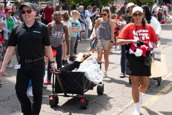 two people pulling a wagon in a parade