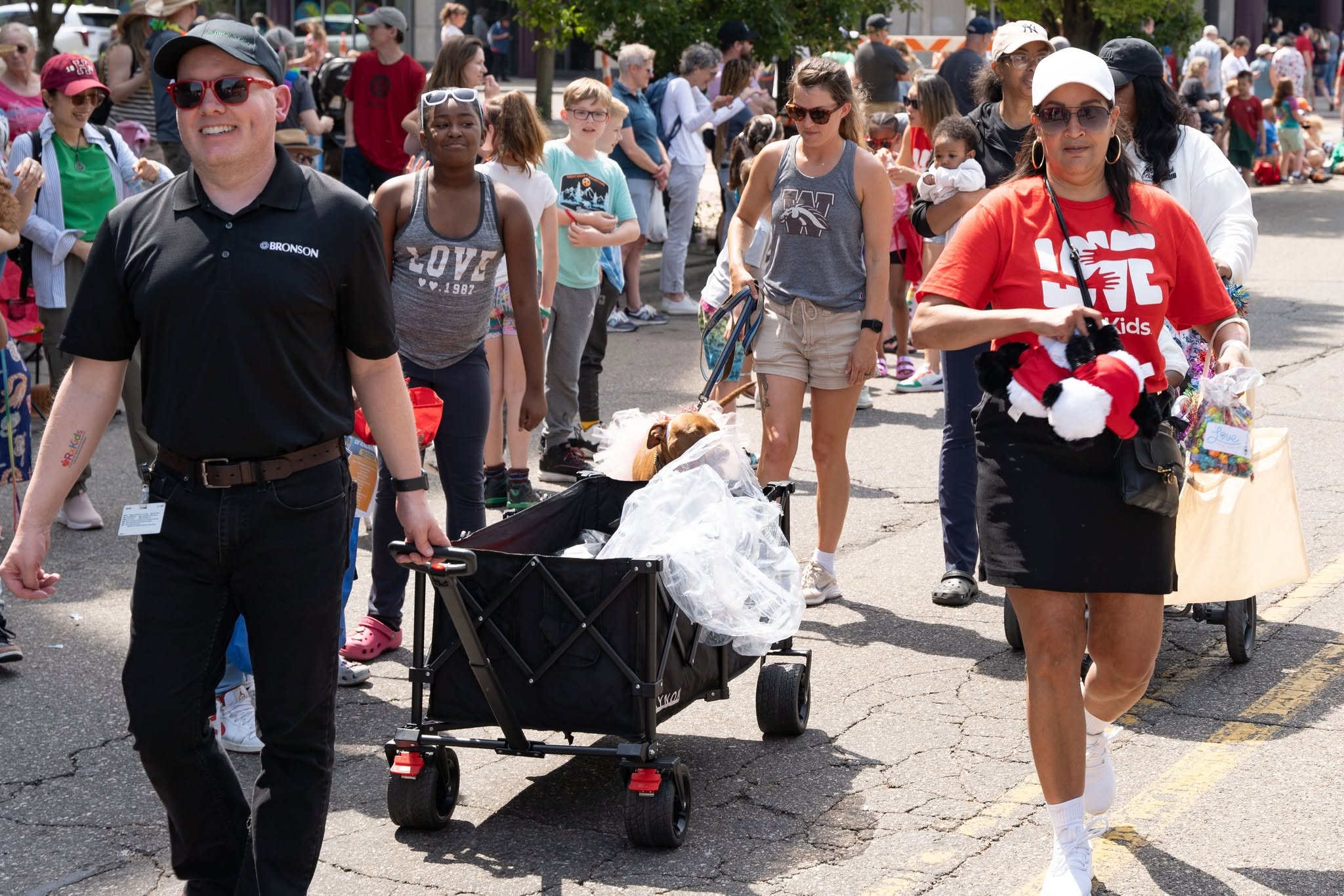 two people pulling a wagon in a parade