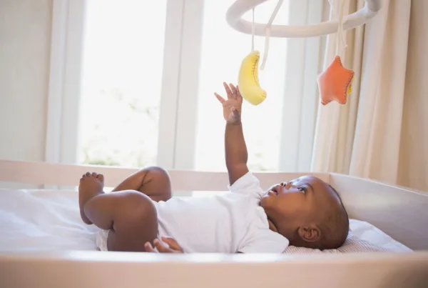 A baby plays with a mobile